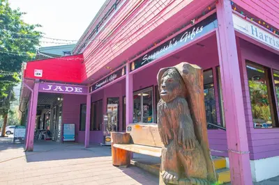 a wooden bench in front of a purple building at The Flats at Cedar Springs with Full Kitchen and Steps to Lake in Harrison Hot Springs