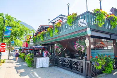a street with a building with flowers and plants at The Flats at Cedar Springs with Full Kitchen and Steps to Lake in Harrison Hot Springs