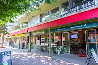 a building with tables and chairs on a street at Beachy 2 Bed Studio Suite, Balcony and 4 Min to Lake in Harrison Hot Springs