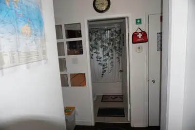 a hallway with a clock on the wall next to a door at Hotel Room 2 in Coquitlam