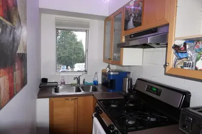a small kitchen with a stove and a sink at Hotel Room 2 in Coquitlam