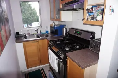 a small kitchen with a stove and a sink at Hotel Room 2 in Coquitlam