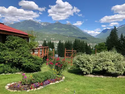a garden with flowers and mountains in the background at Wing Creek Resort in Kaslo
