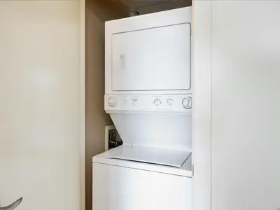 a white washer and dryer in a room at Astoria Escape - Bright condo with work desk by Victoria Prime! in Victoria