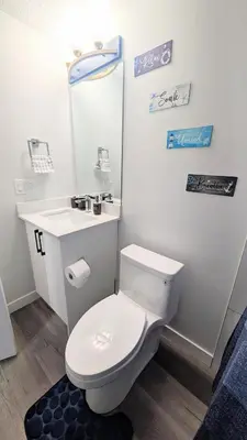 a bathroom with a white toilet and a sink at Cozy Escape Guest Suite in Edmonton