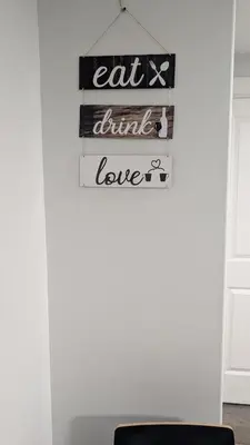 a sign that says eat drink love hanging on a wall at Cozy Escape Guest Suite in Edmonton