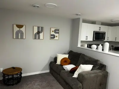 a living room with a couch and a kitchen at Bright & Spacious 2BR Getaway in Calgary