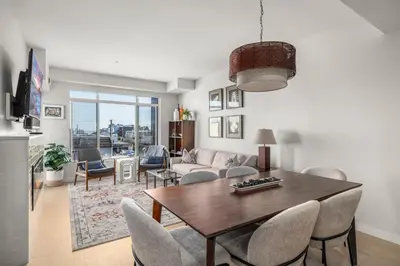 a living room with a wooden table and chairs at Sidney Sunnyside - Luxurious Seaside Living in Amazing Sidney by Victoria Prime! in Sidney