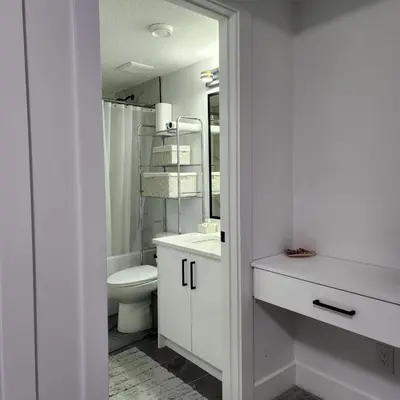 a white bathroom with a toilet and a sink at Studio Suite in Northeast, Edmonton in Edmonton