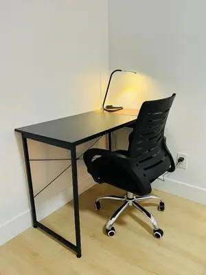 a black desk with a black chair and a lamp at New and Modern 1 bedroom suite near beach in Surrey