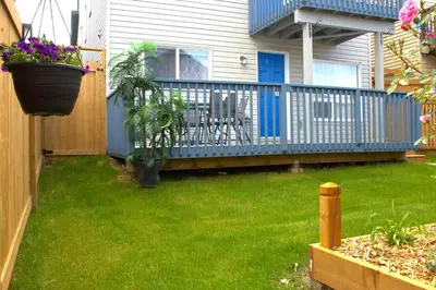 a deck with a table and chairs on a house at Entire suite Queen BRM Big Window Prvt Entry Patio in Edmonton