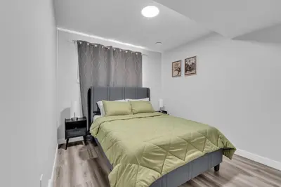 a bedroom with a bed with a green comforter at TheCozyNest in Calgary
