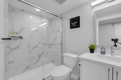 a bathroom with a shower and a toilet and a sink at TheCozyNest in Calgary