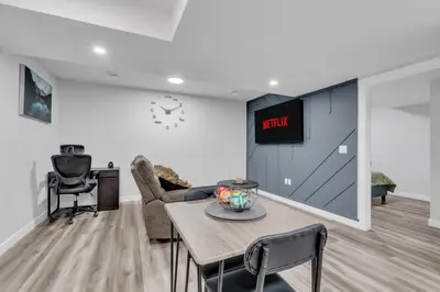 a living room with a table and a tv on a wall at TheCozyNest in Calgary