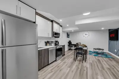 a kitchen with a refrigerator and a table in a room at TheCozyNest in Calgary