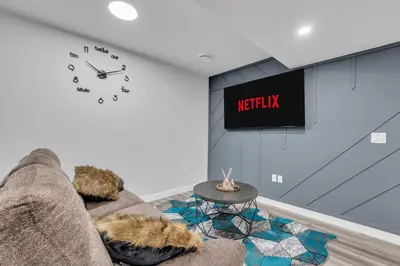 a living room with a couch and a clock on the wall at TheCozyNest in Calgary