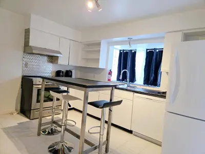 a kitchen with a black counter and stools in it at Charming Beautiful Private Room With Private Bath and Parking! Near Metrotown in Burnaby