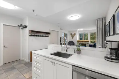 a kitchen with white cabinets and a sink in it at 1BR plus King Murphy Bed in Tyndall Stone Lodge, Village Location, Pool and Hot Tub, Fireplace in Whistler
