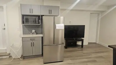 a kitchen with a stainless steel refrigerator and a tv at Your Home - Spacious Private Suite in Delta