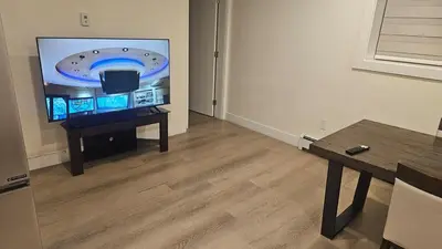 a living room with a flat screen tv and a table at Your Home - Spacious Private Suite in Delta