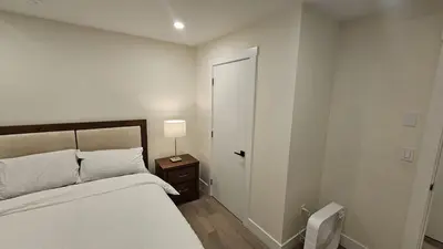 a white bedroom with a bed and a door at Your Home - Spacious Private Suite in Delta