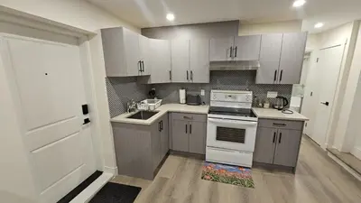 a kitchen with white cabinets and a white stove at Your Home - Spacious Private Suite in Delta