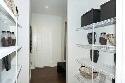 a walk in pantry with white shelves at Strawberry Fields 4BD Family Movie Room Office in Calgary