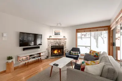 a living room with a couch and a fireplace at 1BR in Powderview, Creekside, Bright and Cozy, Private Ski Storage, Fireplace, Free Parking in Whistler