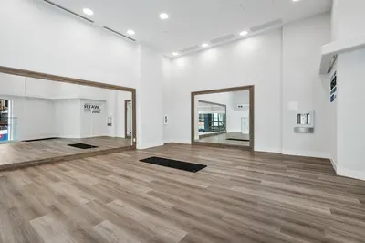 an empty room with wooden floors and a large mirror at AQUA Corner Unit w Balcony and Amazing View #614 in Kelowna