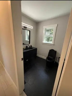 a bathroom with a black toilet and a sink at Modern 5BR Luxury Getaway in Cobble Hill