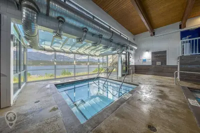 a swimming pool in a building with a large window at Akiskinook Resort by StayIn in Windermere