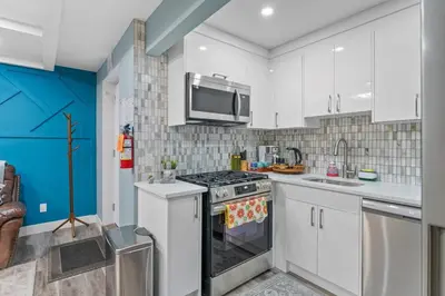 a kitchen with white cabinets and a stove top oven at Private Family Entertainer's Suite in Calgary
