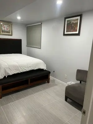 a bedroom with a bed and a chair and a chalkboard at Cozy and comfy 1 BEDROOM basement suite at Cougar ridge SW Calgary in Calgary