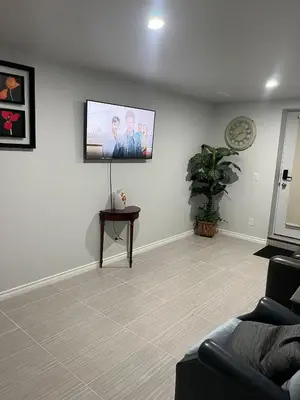 a living room with a flat screen tv on the wall at Cozy and comfy 1 BEDROOM basement suite at Cougar ridge SW Calgary in Calgary