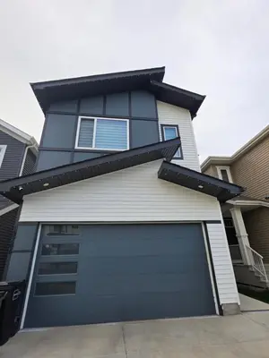 a blue house with a garage door at Cozy Up in Edmonton