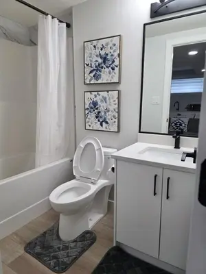 a bathroom with a toilet and a sink and a mirror at Cozy Up in Edmonton