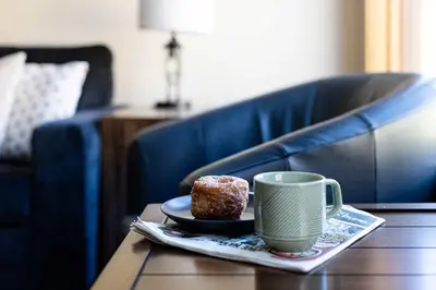 a cup of coffee and a donut on a table at Creekside 2-Bedroom Condo in Canmore