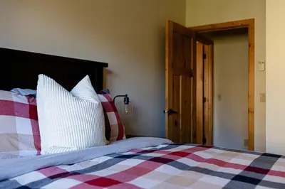 a bedroom with a bed with red and white pillows at Creekside 2-Bedroom Condo in Canmore