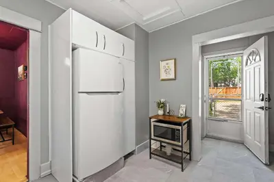 a kitchen with a white refrigerator and a table at The Canary 2BR Gem in Downtown Drumheller in Drumheller