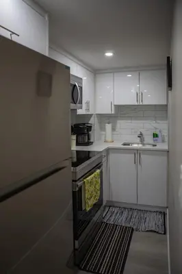 a kitchen with white cabinets and an open oven at Modern 2-Bedroom Suite with Private Access - 10 minutes from Calgary Airport in Calgary