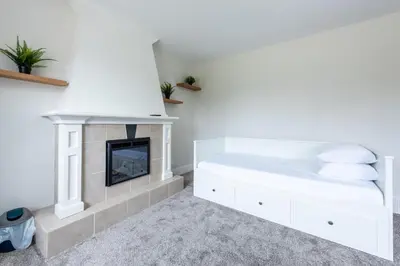 a bedroom with a fireplace and a bed at Valley Villa Spacious 5BD Getaway! Sleep 12, 1hr to Banff, 40 Mins Canmore, 5 mins to WinSport & Olympic park in Calgary