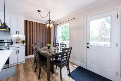 a kitchen and dining room with a table and chairs at Valley Villa Spacious 5BD Getaway! Sleep 12, 1hr to Banff, 40 Mins Canmore, 5 mins to WinSport & Olympic park in Calgary