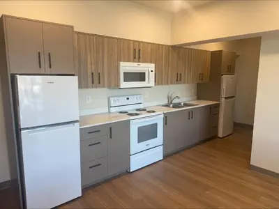 a kitchen with white appliances and wooden cabinets at Residence & Conference Centre - Kelowna in Kelowna