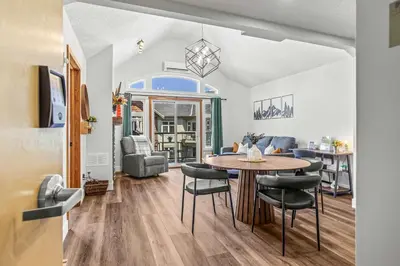 a dining room and living room with a table and chairs at Mountain Views Balcony and Free Parking in Canmore