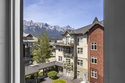 a view of a building with mountains in the background at Mountain Views Balcony and Free Parking in Canmore
