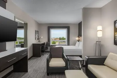 a hotel room with a bedroom with a bed and a tv at Holiday Inn Express & Suites Cold Lake by IHG in Cold Lake
