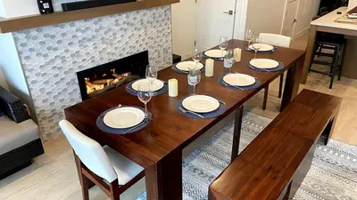 a dining room table with chairs and a fireplace at I Beach You To It in Oyster Bay
