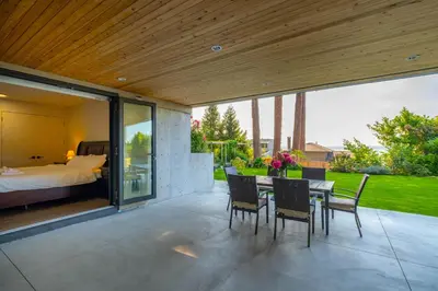 a patio with a bed and a table and chairs at New 2BR Suite With Great Ocean View in West Vancouver in West Vancouver
