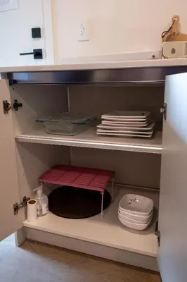 a cabinet with a stack of plates and a toilet at New 2BR Suite With Great Ocean View in West Vancouver in West Vancouver