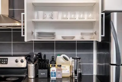 a kitchen with a counter top with dishes on shelves at Spacious Downtown Condo with Pool Gym & Parking in Vancouver